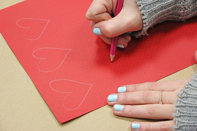 drawing hearts on red paper